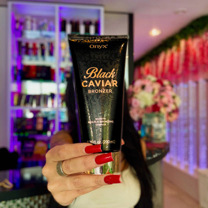 Bräunungslotion fürs Solarium, Hand mit roten Nägeln hält die Onyx Black Caviar Tube vor Produktauswahl