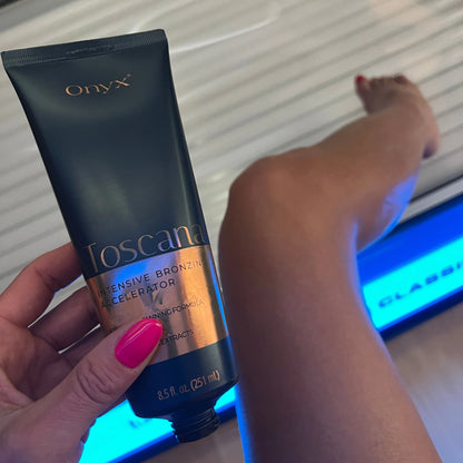 Geöffnete Onyx Toscana Sonnenbank-Bräunungscreme vor Bein im Solarium mit pink lackierten Nägeln